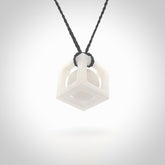 A hand carved medium sized white nephrite Jade square box with ball inside necklace. The cord is blue and adjustable in length. A medium sized hand made cube/box with ball necklace in white nephrite Jade stone. One off work of art to wear.